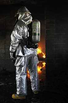 A firefighter waits for a fire to get bigger before attempting to extinguish the flames A firefighter waits for a fire to get bigger before attempting to extinguish the flames