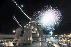 Fireworks light up the sky behind the guided missile destroyer JS Kirishima Fireworks light up the sky behind the guided missile destroyer JS Kirishima