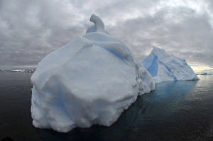 Floating iceberg with grey sky and black sea, Antarctica Floating iceberg with grey sky and black sea, Antarctica