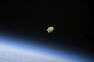 A gibbous moon visible above Earths atmosphere A gibbous moon visible above Earths atmosphere