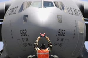 Ground crewmember marshals a C-17 Globemaster III to its parking spot Ground crewmember marshals a C-17 Globemaster III to its parking spot