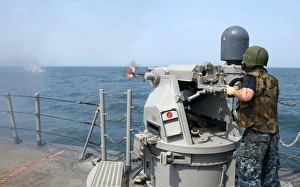 Gunners Mate fires a 25mm chain gun aboard USS Cape St. George Gunners Mate fires a 25mm chain gun aboard USS Cape St. George