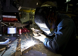 Hull Maintenance Technician strikes a welding rod Hull Maintenance Technician strikes a welding rod