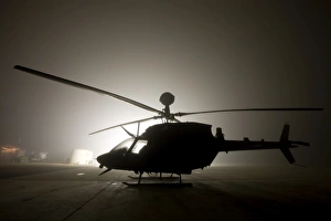The illumination from the bright light silhouettes a OH-58D Kiowa helicopter during The illumination from the bright light silhouettes a OH-58D Kiowa helicopter during