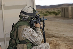 An infantry scout sights-in around the corner of a building An infantry scout sights-in around the corner of a building