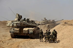 An Israel Defense Force Merkava Mark IV battle tank with infantry forces An Israel Defense Force Merkava Mark IV battle tank with infantry forces