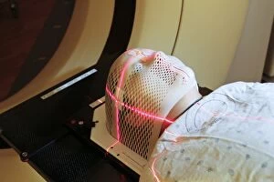 Laser Gallery: Lasers used to position a patient wearing a short face mask in a computed tomography