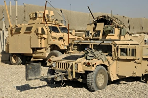 A M1114 humvee sits parked in front of a MaxxPro MRAP A M1114 humvee sits parked in front of a MaxxPro MRAP