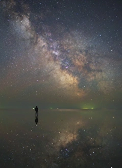 Man stands alone on Lake Elton in Russia under the center of the Milky Way Man stands alone on Lake Elton in Russia under the center of the Milky Way