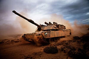 Images Dated 10th April 2012: Marines roll down a dirt road on their M1A1 Abrams Main Battle Tank