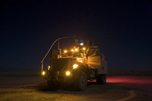 A MaxxPro MRAP vehicle with running lights on at night A MaxxPro MRAP vehicle with running lights on at night