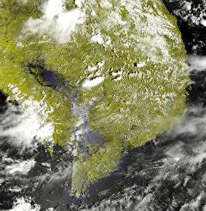 <b class=qtipBold><figcaption>Mekong Delta and the Tonle Sap</figcaption></b><br>Heavy rains in Indochina over the past month caused seasonal flooding in the Mekong Delta. This false-color image of the delta and the nearby Tonle Sap was acquired on September 7, 2002, by the Moderate Resolution Imaging Spectroradiometer (MODIS) aboard NASA's Terra spacecraft. Normally, the Tonle Sap, which is the oblong body of water pointing toward the left-hand corner of the image, appears as a well-defined lake separated from the Gulf of Thailand by green wetlands. During the rainy season, however, the flow of the Mekong River, running down the center of the image, increases. The excess water backs up at the Mekong Delta on the right-hand side of the pennisula and flows west into the Tonle Sap and the surrounding wetlands. The result is the large uninterrupted lake that appears as an extension of the Gulf of Thailand in the image. In this false-color image, clouds area white, land is pea green, and water is black and blue.<br><em>© Stocktrek Images</em> Mekong Delta and the Tonle Sap