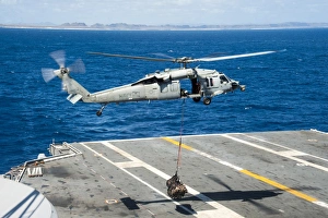 An MH-60S Sea Hawk delivers supplies onto the flight deck of USS George Washington An MH-60S Sea Hawk delivers supplies onto the flight deck of USS George Washington