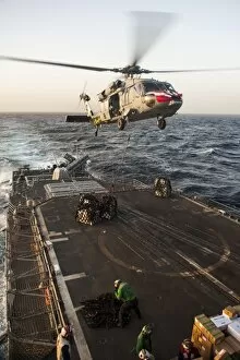 Images Dated 16th February 2013: An MH-60S Sea Hawk helicopter delivers cargo to USS Mobile Bay