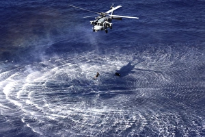An MH-60S Seahawk lowers a rescue swimmer into the water An MH-60S Seahawk lowers a rescue swimmer into the water