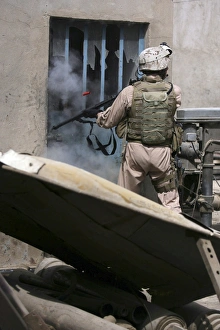 A military policeman uses a breaching round to open a lock A military policeman uses a breaching round to open a lock
