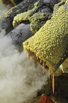 Molten sulphur trickling out of condensation pipe, Kawah Ijen volcano, Java, Indonesia Molten sulphur trickling out of condensation pipe, Kawah Ijen volcano, Java, Indonesia