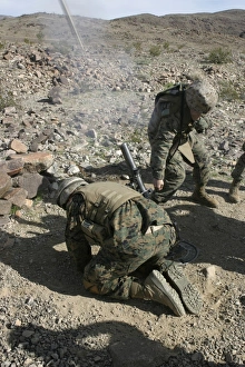 Mortarmen cover their ears and avert their eyes after firing their 60mm mortar weapons Mortarmen cover their ears and avert their eyes after firing their 60mm mortar weapons