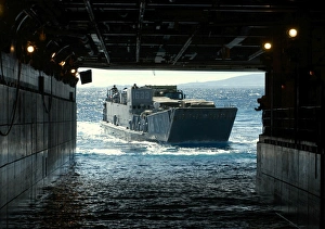 A Navy Landing Craft Utility approaches the well deck of USS Tarawa off the coast A Navy Landing Craft Utility approaches the well deck of USS Tarawa off the coast