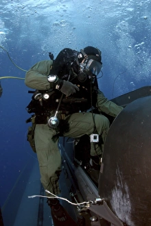 A Navy SEAL climbs aboard a SEAL Delivery vehicle before launching from a submarine A Navy SEAL climbs aboard a SEAL Delivery vehicle before launching from a submarine