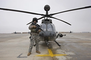 An OH-58D Kiowa Warrior pilot stands beside his aircraft An OH-58D Kiowa Warrior pilot stands beside his aircraft