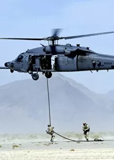 Images Dated 8th October 2004: Pararescuemen descend from an HH-60 Pave Hawk helicopter
