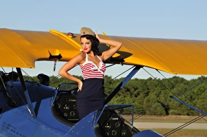 Patriotic pin-up girl standing inside the cockpit of a Stearman biplane Patriotic pin-up girl standing inside the cockpit of a Stearman biplane