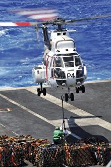 Personnel connect a cargo pendant to an SA-330 Puma helicopter Personnel connect a cargo pendant to an SA-330 Puma helicopter