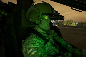 Pilot equipped with night vision goggles in the cockpit of an Apache helicopter Pilot equipped with night vision goggles in the cockpit of an Apache helicopter