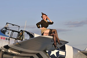 Pin-up girl sitting on the wing of a P-51 Mustang Pin-up girl sitting on the wing of a P-51 Mustang