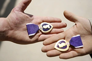 Purple Heart recipients display their medals in their hands Purple Heart recipients display their medals in their hands