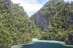 Rugged limestone islands surround corals growing in a gorgeous lagoon Rugged limestone islands surround corals growing in a gorgeous lagoon