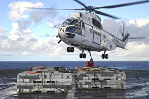 Sailors attach cargo legs to an SA330J Puma helicopter Sailors attach cargo legs to an SA330J Puma helicopter