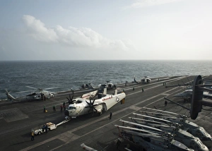 Sailors move a C-2A Greyhound across the flight deck of USS Nimitz Sailors move a C-2A Greyhound across the flight deck of USS Nimitz