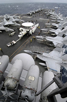 Sailors move an E-2C Hawkeye down the crowded flight deck aboard USS Kitty Hawk Sailors move an E-2C Hawkeye down the crowded flight deck aboard USS Kitty Hawk