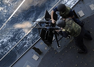 Sailors fire a dual-mounted M240 machine gun aboard USS Bunker Hill Sailors fire a dual-mounted M240 machine gun aboard USS Bunker Hill