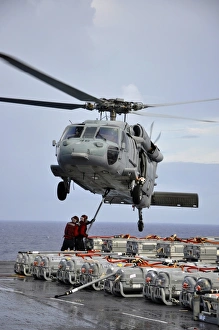Sailors hook an ammunition pallet to an MH-60S Sea Hawk helicopter Sailors hook an ammunition pallet to an MH-60S Sea Hawk helicopter