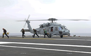 Sailors leave the landing area of an HH-60H Sea Hawk helicopter Sailors leave the landing area of an HH-60H Sea Hawk helicopter