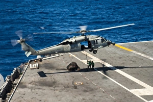 Sailors prepare to connect cargo legs and nets to an MH-60S Sea Hawk Sailors prepare to connect cargo legs and nets to an MH-60S Sea Hawk