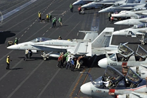 Sailors push an F/A-18C Hornet in preparation for flight operations Sailors push an F/A-18C Hornet in preparation for flight operations
