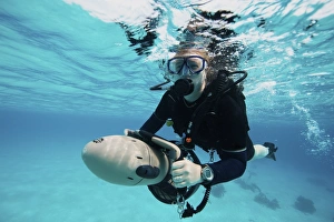 Scuba diver navigates the waters using a diver propulsion vehicle Scuba diver navigates the waters using a diver propulsion vehicle