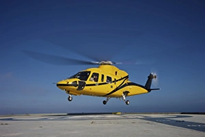 A Sikorsky S-76 utility helicopter taking off from an oil rig A Sikorsky S-76 utility helicopter taking off from an oil rig