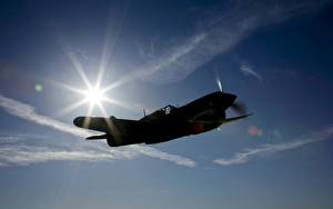 Silhouette of a Curtiss P-40E Warhawk in flight near Chino, California Silhouette of a Curtiss P-40E Warhawk in flight near Chino, California