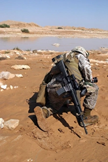 Soldier patrols along a riverbed on a search and rescue mission Soldier patrols along a riverbed on a search and rescue mission