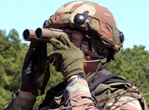 A soldier scans an area for enemy forces A soldier scans an area for enemy forces