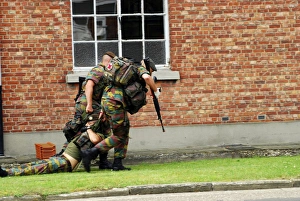 Soldiers of the Belgian Army helping and transporting a wounded mate Soldiers of the Belgian Army helping and transporting a wounded mate