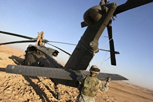 Soldiers prepare a UH-60 Black Hawk helicopter for transport Soldiers prepare a UH-60 Black Hawk helicopter for transport