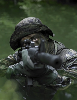 Special operations forces soldier transits the water armed with an assault rifle Special operations forces soldier transits the water armed with an assault rifle