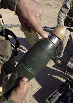 A squad leader points to a delay setting on an 81mm mortar round A squad leader points to a delay setting on an 81mm mortar round
