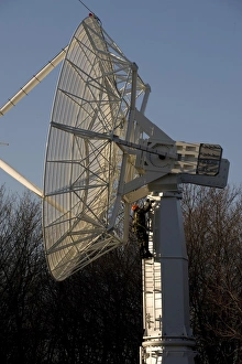 A technician climbs up a large radio telescope antenna A technician climbs up a large radio telescope antenna
